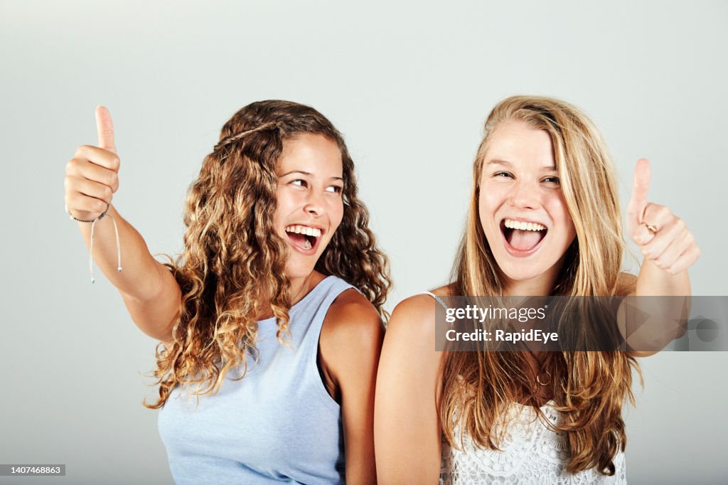 Two beautiful young people smile, laugh and give the thumbs-up sign