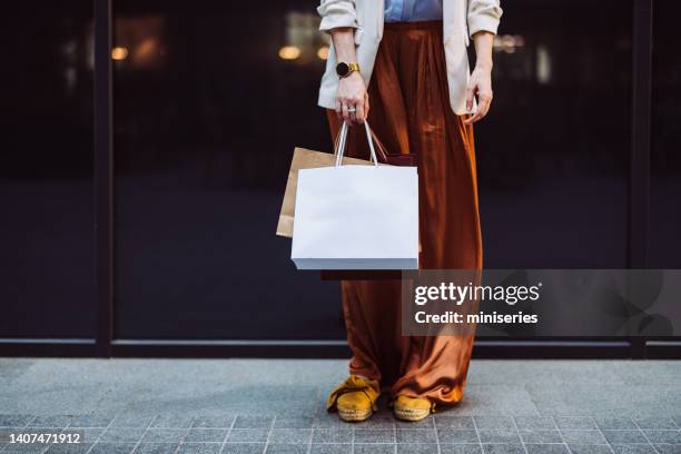 una mujer anónima que lleva bolsas de compras al aire libre - woman carrying tote bag fotografías e imágenes de stock