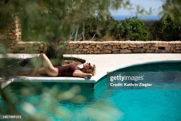 woman relaxing poolside, ibiza, spain - wellness olive tree stock pictures, royalty-free photos & images