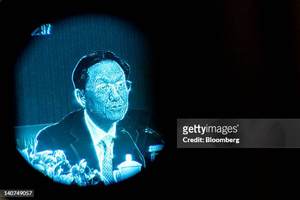 Xie Xuren, China's finance minister, is seen through a television camera's eye piece as he speaks during a news conference at the China's National...
