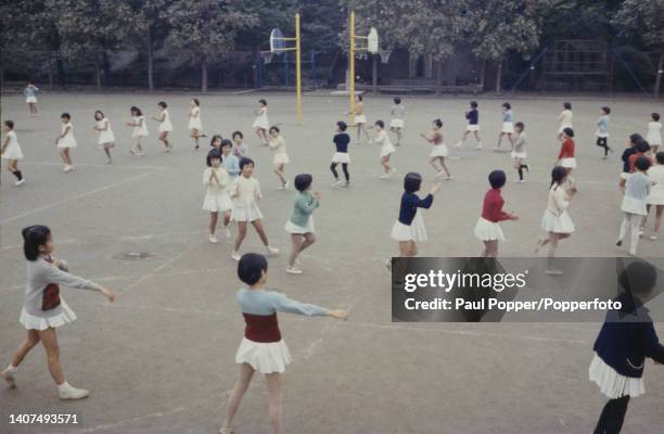 School children take part in an exercise class for girls in a playground at Ochanomizu University elementary school in the Bunkyo district of Tokyo...