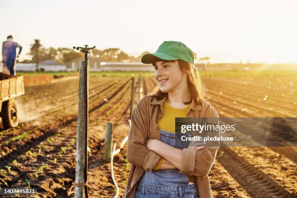 one happy proud young farm manager working on organic sustainable crops to cultivate vegetation in agribusiness. confident smiling woman thinking about harvest of fresh crops in startup garden - create and cultivate stock pictures, royalty-free photos & images