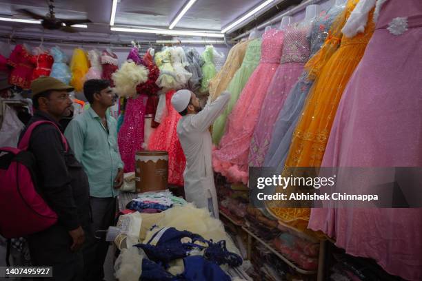 Muslim men buy new clothes inside a shop ahead of Eid al-Adha on July 08, 2022 in Bengaluru, India. Muslims around the world will celebrate Eid...