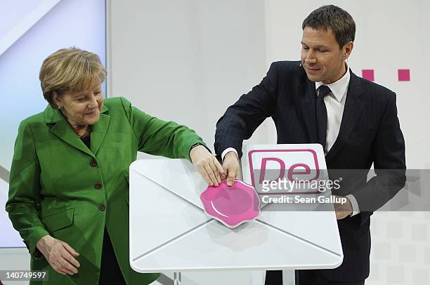 German Chancellor Angela Merkel and Deutsche Telekom CEO Rene Obermann attend a presentation of Deutsche Telekom's new De-Mail secure e-mail system...