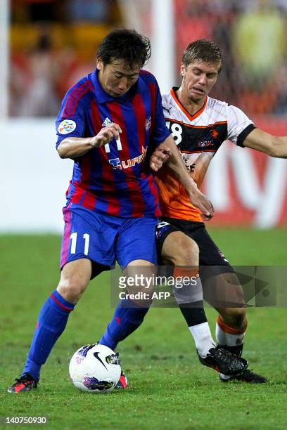 Watanabe Kazuma of FC Tokyo dribbles past Like Brattan of Brisbane Roar during the group F football match of the AFC Champions League in Brisbane on...