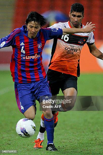 Takahashi Hzdeto of FC Tokyo dribbles past Sayed Mohamed Adnan of Brisbane Roar during the group F football match of the AFC Champions League in...