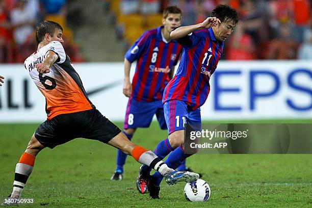 Watanabe Kazuma of FC Tokyo dribbles past Erik Paartalu of Brisbane Roar during the group F football match of the AFC Champions League in Brisbane on...