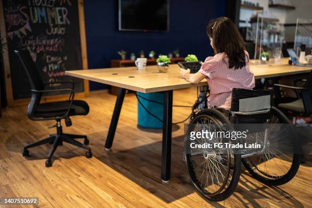 disabled woman working at office - paraplegic stock pictures, royalty-free photos & images