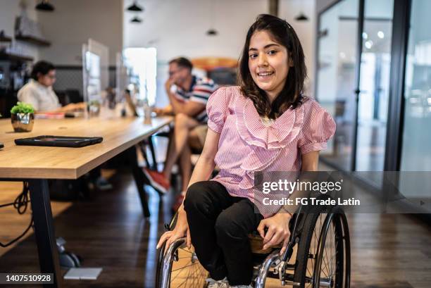 portrait of disabled young woman at the office - spinal cord injury stock pictures, royalty-free photos & images