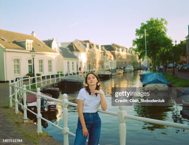 mujer de pie cerca del canal con atuendo vintage - leiden nederland fotografías e imágenes de stock