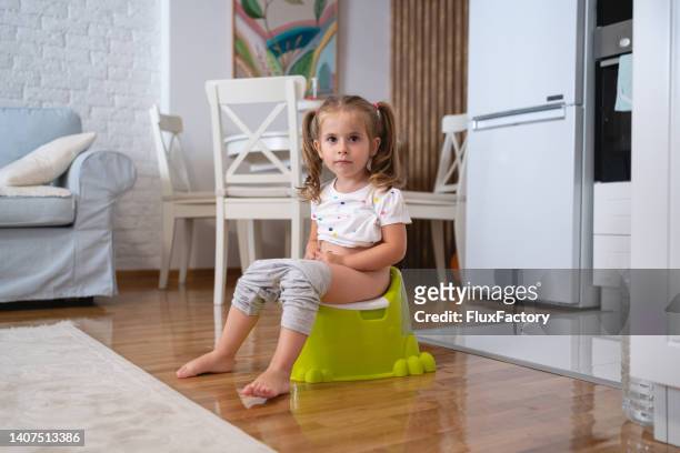 niña pequeña en un orinal en la sala de estar - girls peeing fotografías e imágenes de stock