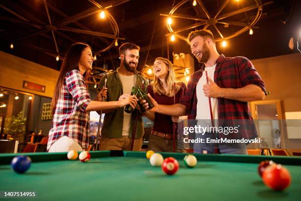 jugar al billar y beber cerveza con amigos en el salón de la piscina local - pool table fotografías e imágenes de stock