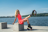 young sports trainer with beautiful legs in a pink dress jumps on spring shoes near the lake.