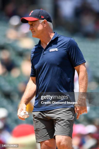 Executive Vice President of Football Operations Daryl Johnston walks onto the field to throw the ceremonial first pitch prior to a game between the...