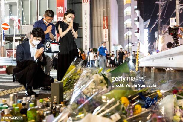 People pray at a site outside of Yamato-Saidaiji Station where Japan’s former prime minister Shinzo Abe was shot earlier today during an election...