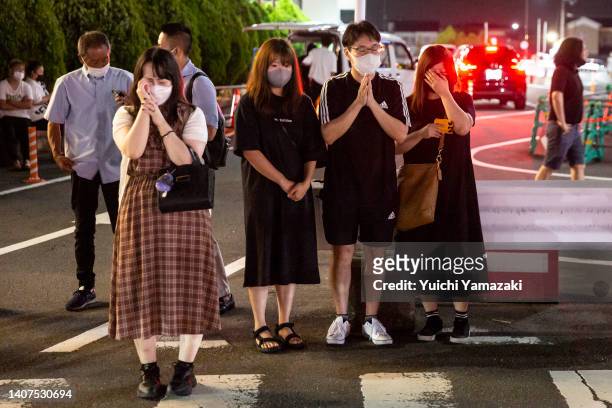 People pray and cry at a site outside of Yamato-Saidaiji Station where Japan’s former prime minister Shinzo Abe was shot earlier today during an...