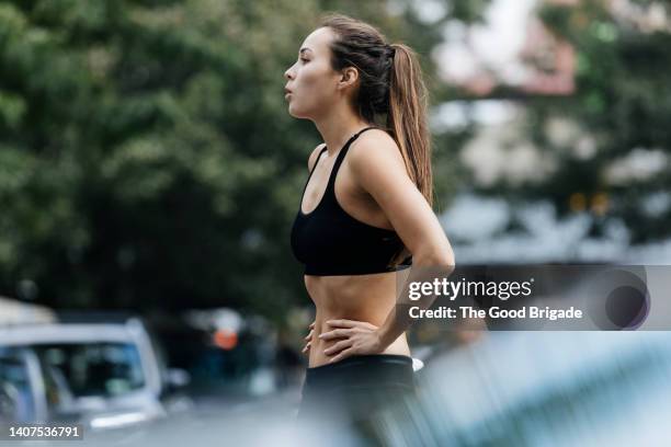 woman with hands on hips resting after exercise - runner resting stock pictures, royalty-free photos & images