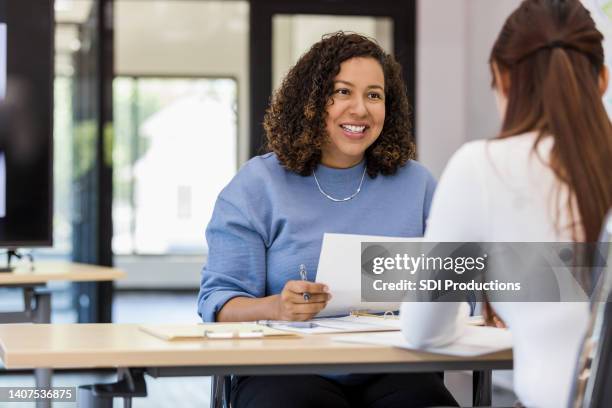 office manager talks to the new intern - boss and employee stockfoto's en -beelden