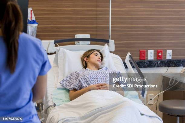 depressed female patient lies on gurney in emergency room - bedside manner stock pictures, royalty-free photos & images