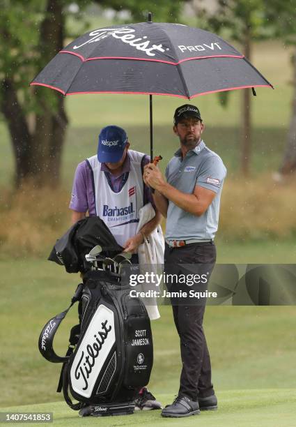 Scott Jamieson of the United States stands under an umbrella as rain falls during the second round of the Barbasol Championship at Keene Trace Golf...