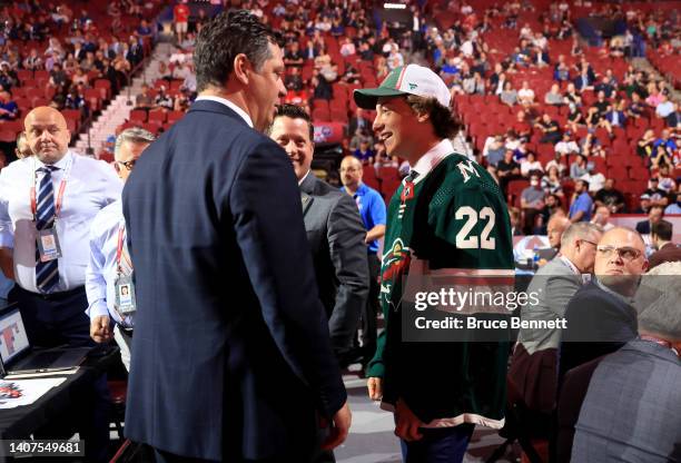 Ryan Healey talks with general manager Bill Guerin after being selected by the Minnesota Wild during Round Four of the 2022 Upper Deck NHL Draft at...