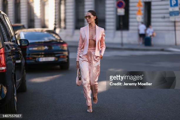 Sabina Jakubowicz seen wearing gold/brown sunglasses from Fendi, a light pink satin bralette/bra underwear from Fendi, a light pink satin/silk short...