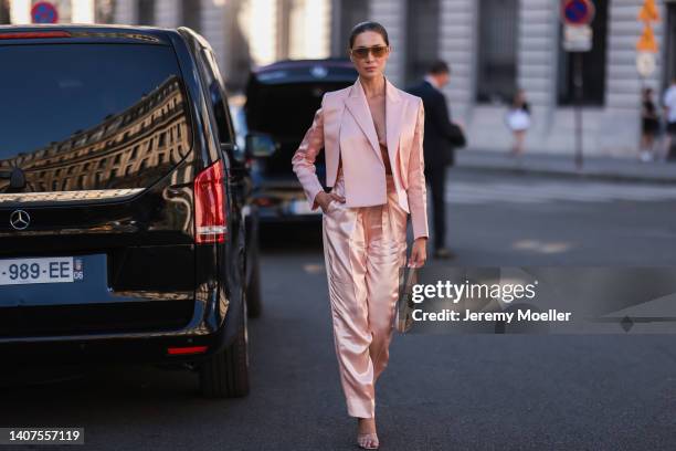 Sabina Jakubowicz seen wearing gold/brown sunglasses from Fendi, a light pink satin bralette/bra underwear from Fendi, a light pink satin/silk short...