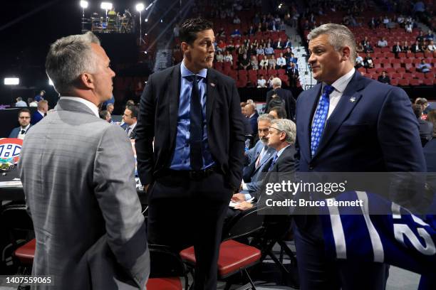 Martin St. Louis, Vincent Lecavalier and Sheldon Keefe talk on the draft floor during Round Six of the 2022 Upper Deck NHL Draft at Bell Centre on...