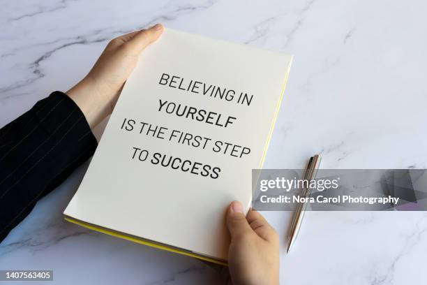 hand holding a note pad with inspirational quotes about success - health motivational quotes stock pictures, royalty-free photos & images