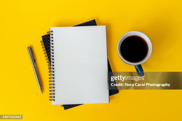 note pad, pen and cup of coffee on yellow background - bloco espiral imagens e fotografias de stock