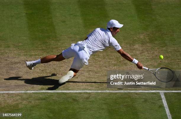 Novak Djokovic of Serbia falls against Cameron Norrie of Great Britain during the Mens' Singles Semi Final match on day twelve of The Championships...