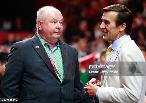 Head coach Bruce Boudreau of the Vancouver Canucks and president George McPhee of the Vegas Golden Knights talk on the draft floor during the 2022...