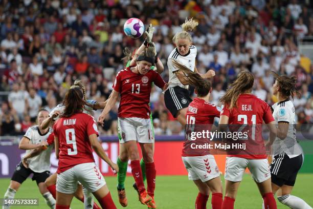 Lea Schueller of Germany scores their team's second goal under pressure from goalkeeper Lene Christensen and Sofie Pedersen of Denmark during the...