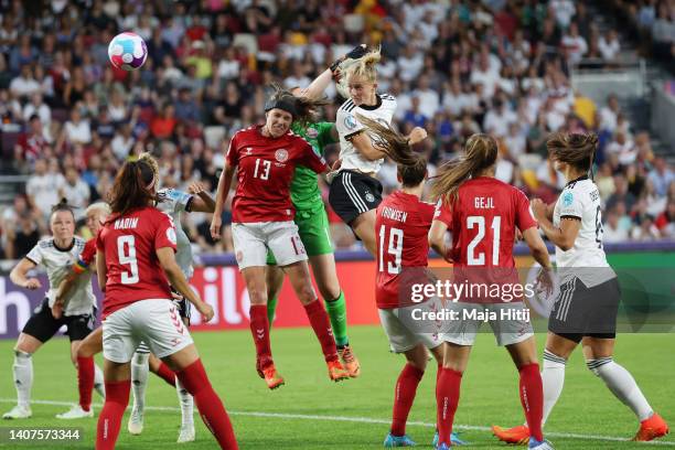 Lea Schueller of Germany scores their team's second goal under pressure from goalkeeper Lene Christensen and Sofie Pedersen of Denmark during the...