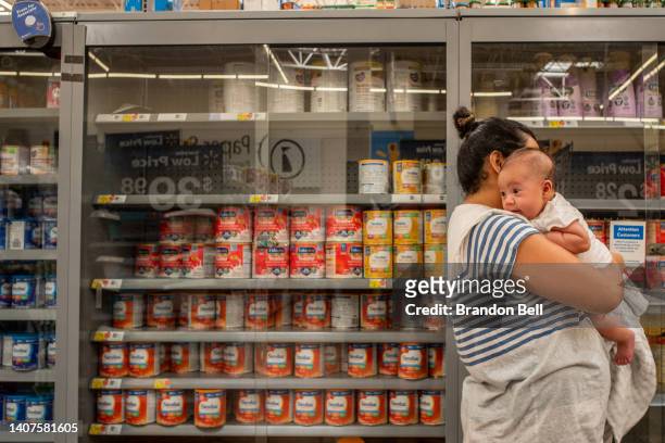 The Reyes family wait to receive baby formula in a Walmart Supercenter on July 08, 2022 in Houston, Texas. Consumer goods continue seeing shortages...