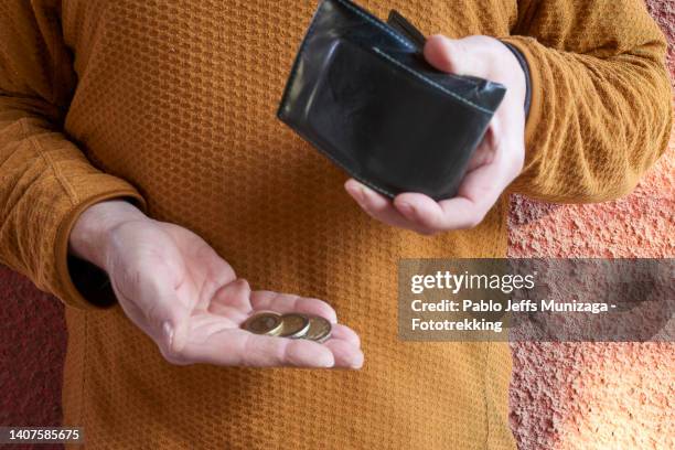 a person holds some coins in his hand - austerity imagens e fotografias de stock