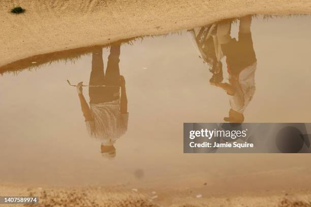 Reflection in the water as Wesley Bryan of the United States prepares to play a shot from the bunker on the 18th hole during the second round of the...