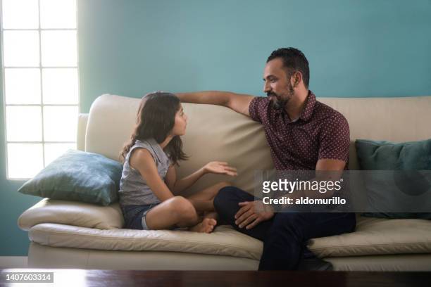 padre e figlia seduti sul divano e che discutono - parent foto e immagini stock