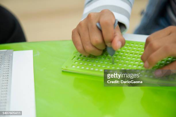 niña ciega aprendiendo a escribir braille - assistive technology fotografías e imágenes de stock