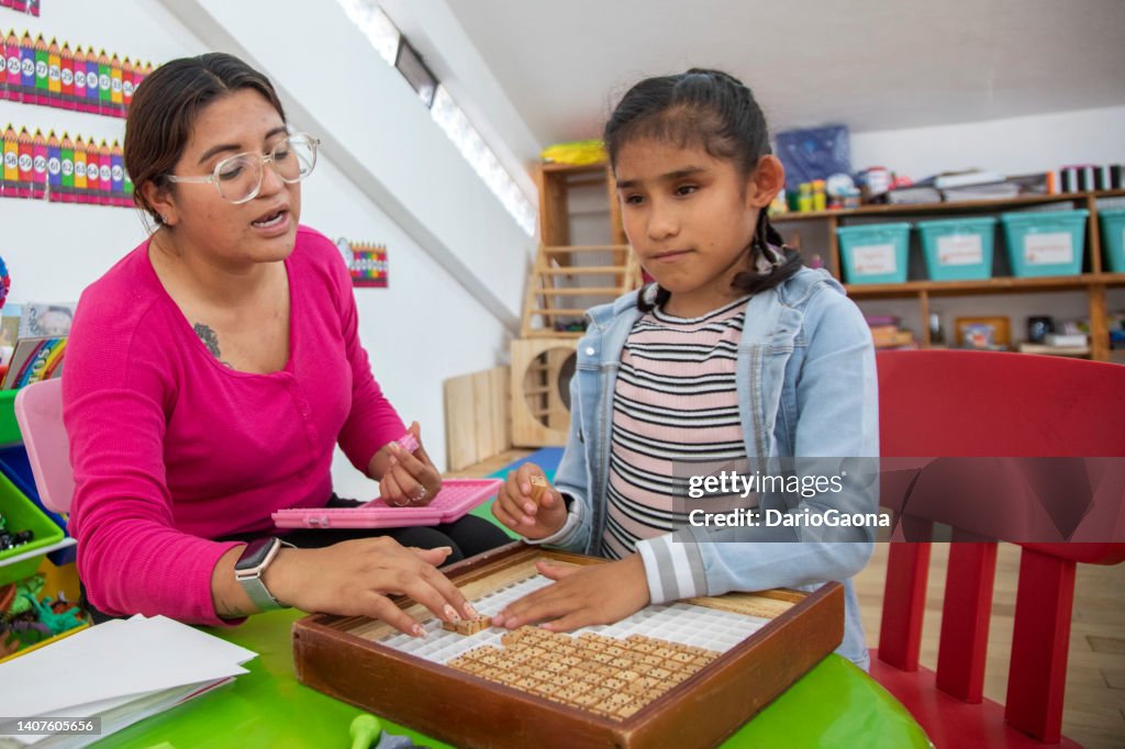 Maestra enseñando matemáticas a niña ciega