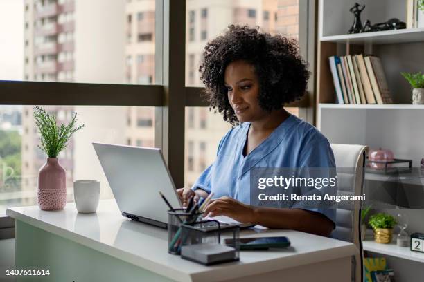african american nurse working on the desk - doctor on computer stock pictures, royalty-free photos & images