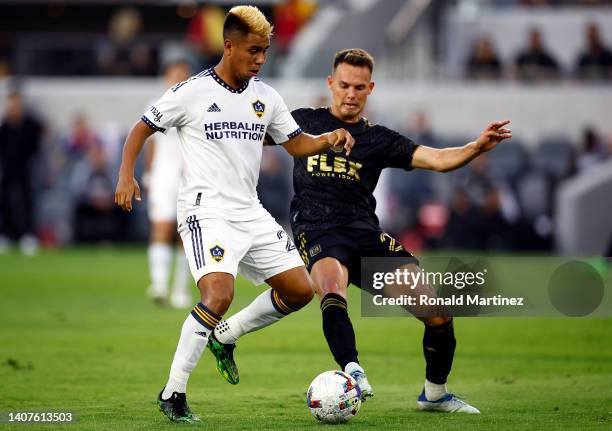 Efrain Alvarez of Los Angeles Galaxy controls the ball against Danny Musovski of Los Angeles FC in the first half at Banc of California Stadium on...