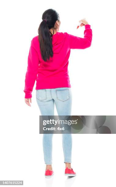 generation z young women teacher standing in front of white background wearing canvas shoe and using pen - woman front and back stockfoto's en -beelden