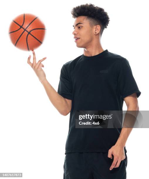 African Ethnicity Young Male Spinning In Front Of White Background Wearing Sports Clothing And Holding Basketball Ball And Using Sports Ball High-Res Stock Photo