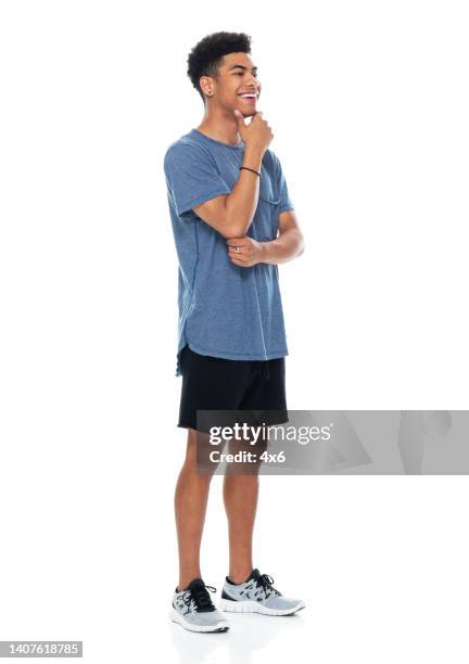 generation z young male standing in front of white background wearing t-shirt - teen boy shorts stock pictures, royalty-free photos & images