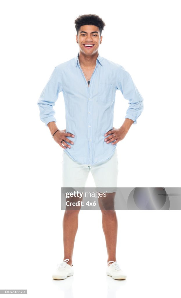 African-american ethnicity young male standing in front of white background wearing canvas shoe
