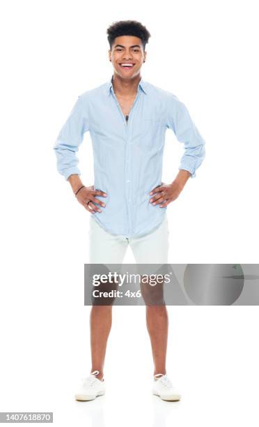 african-american ethnicity young male standing in front of white background wearing canvas shoe - teen boy shorts stock pictures, royalty-free photos & images