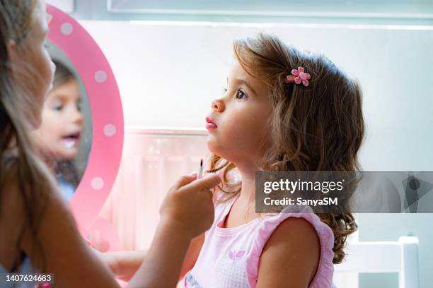 beautiful little girls applying make up - beleza e cuidados corporais imagens e fotografias de stock