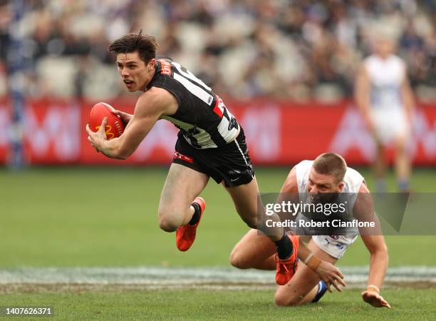 Oliver Henry of the Magpies runs with the ball during the round 17 AFL match between the Collingwood Magpies and the North Melbourne Kangaroos at...