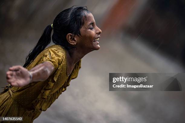 side profile of a girl bathing in rainy season - indian slums stock pictures, royalty-free photos & images